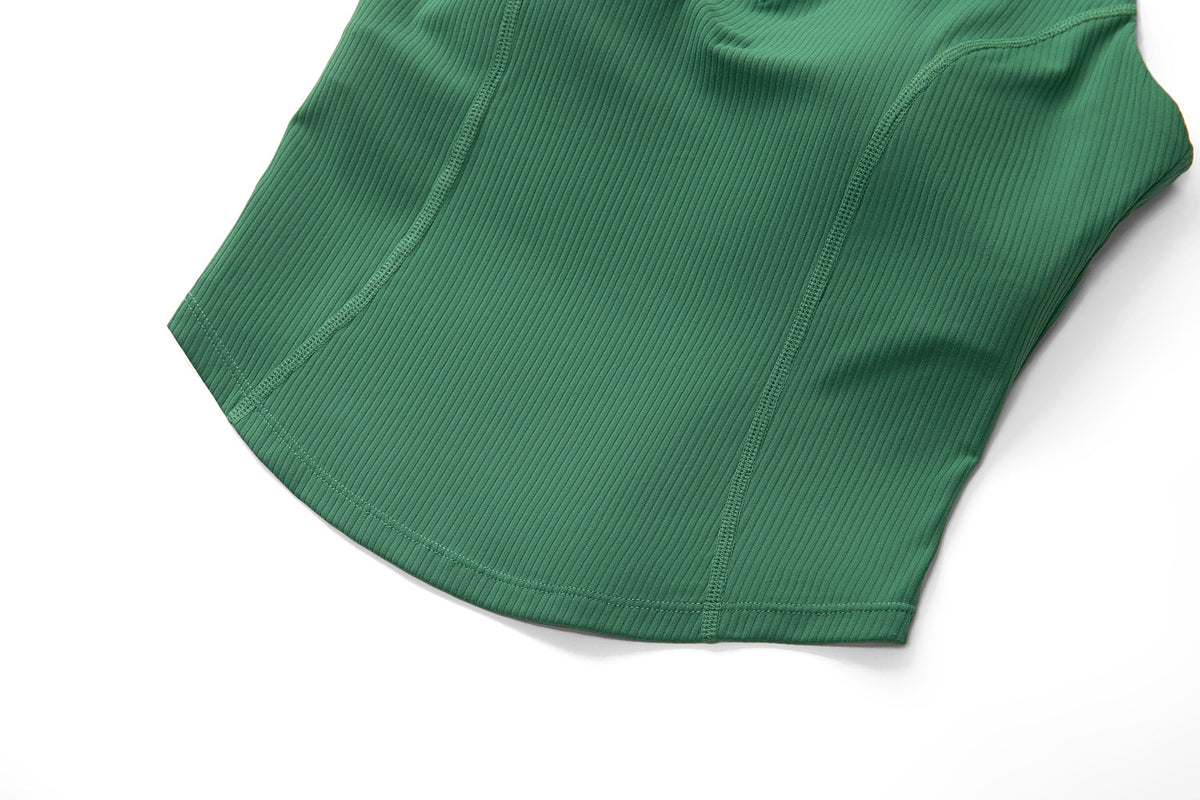 Close-up of the curved hem and contour seams on the green ribbed sleeveless golf top