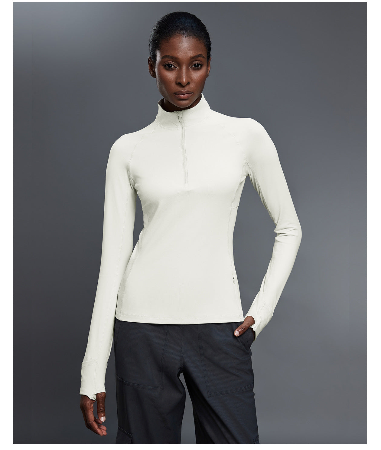White fitted quarter-zip pullover with black trousers, full-length front view with a hand in the trouser pocket