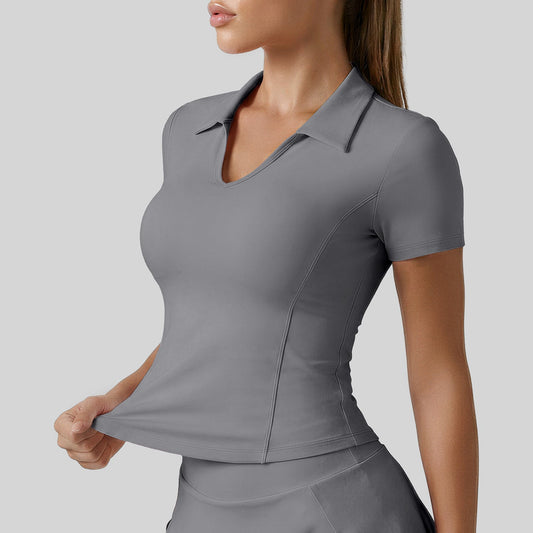Gray open collar V-neck golf polo, front view with hands at the hem to show the fitted seamed shape