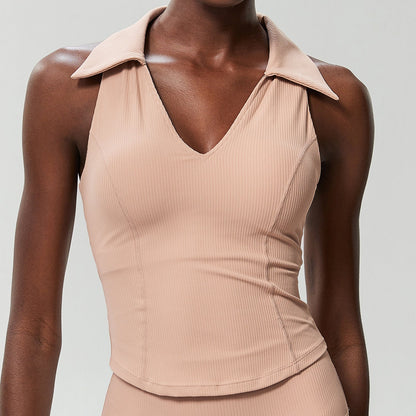 Beige ribbed sleeveless golf top on a model, front view showing the ribbed knit and curved hem