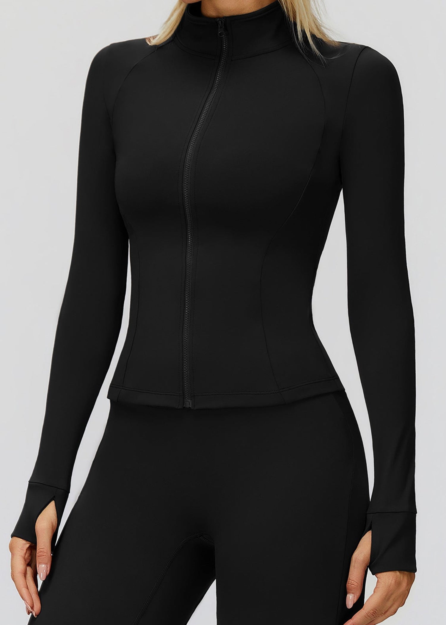 Black fitted golf jacket zipped to the stand collar, close front view showing curved seams and thumbholes