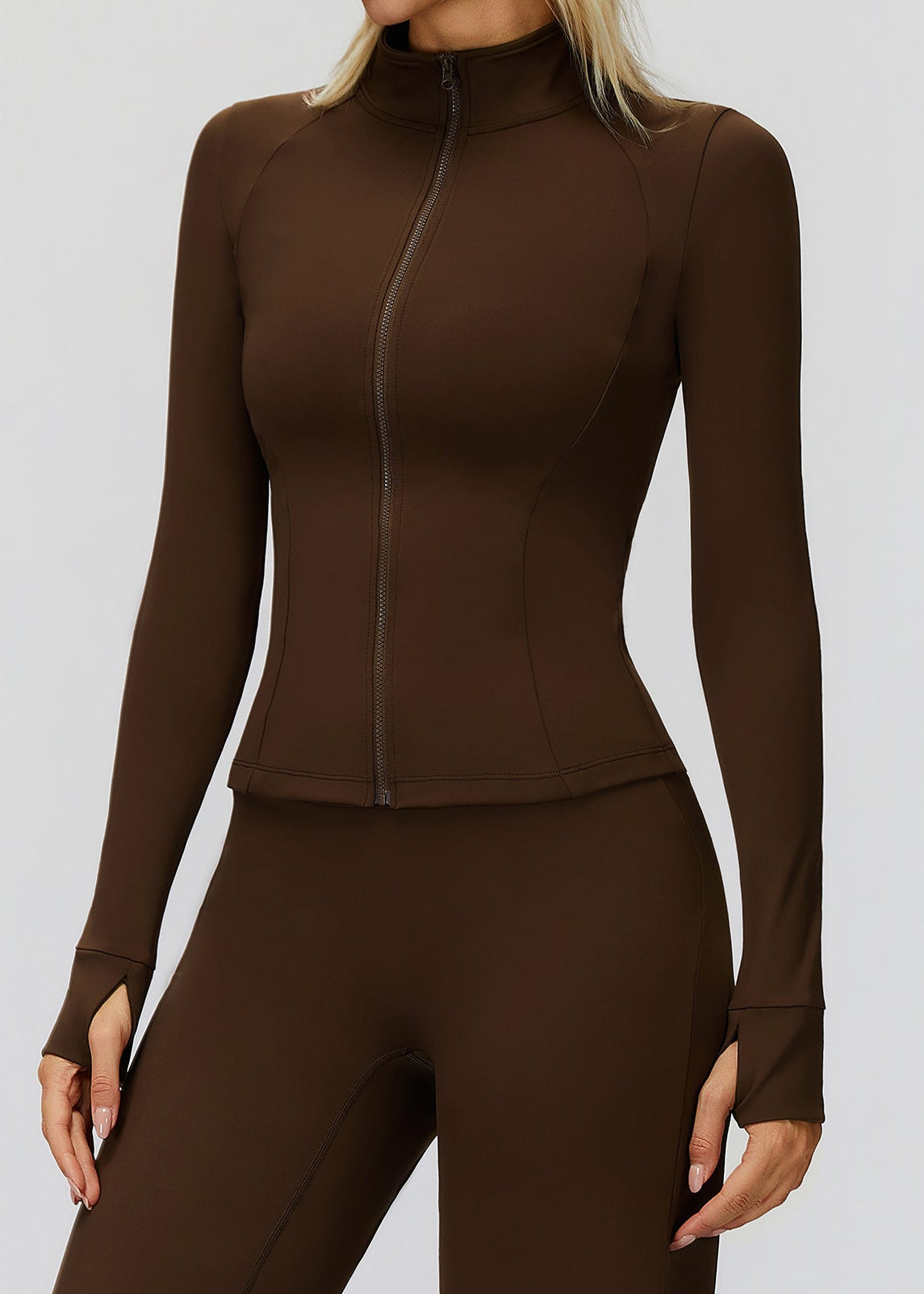 Close front view of brown golf jacket showing the zip running from the stand collar to the hem and curved seams