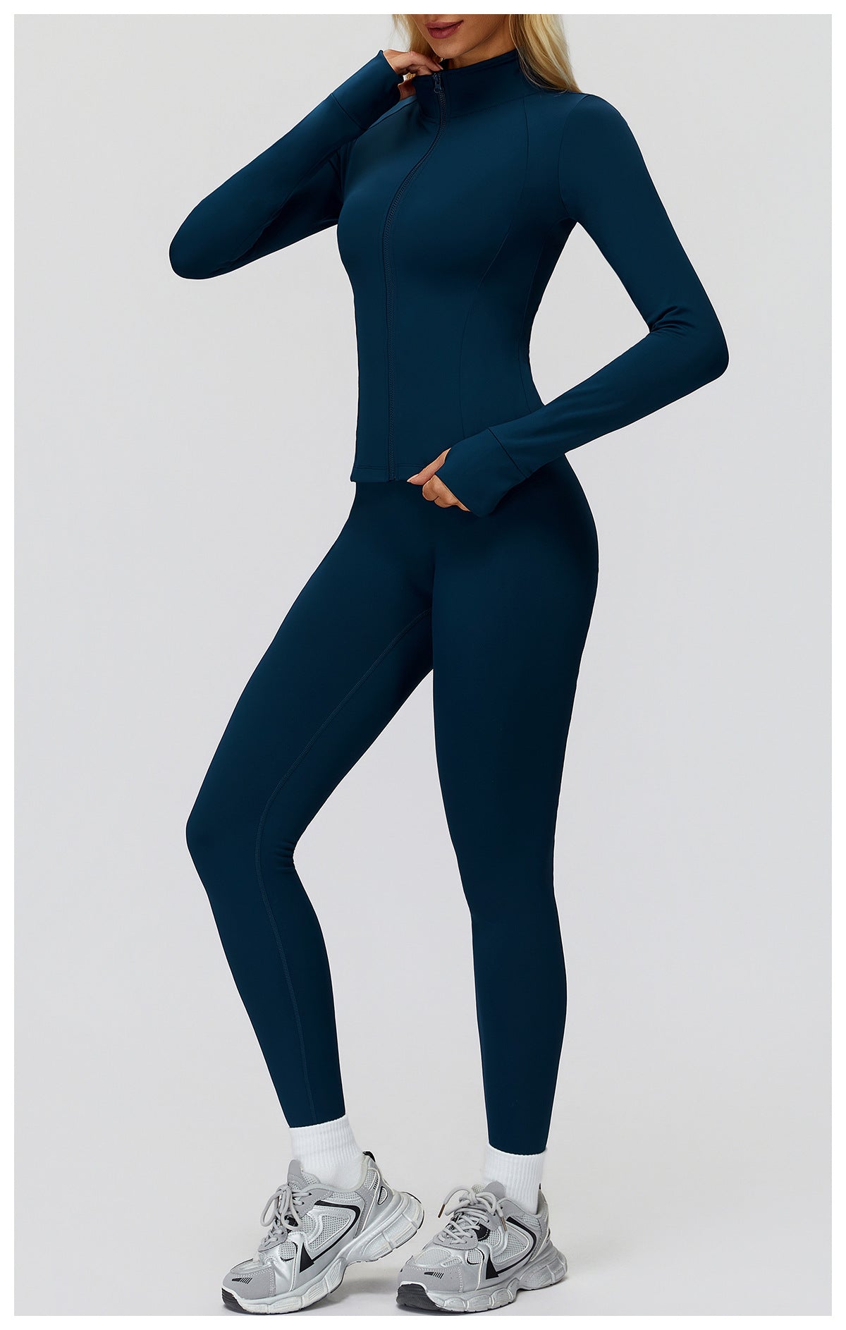 Navy full-zip golf jacket with matching leggings, full-length three-quarter view with a hand at the collar