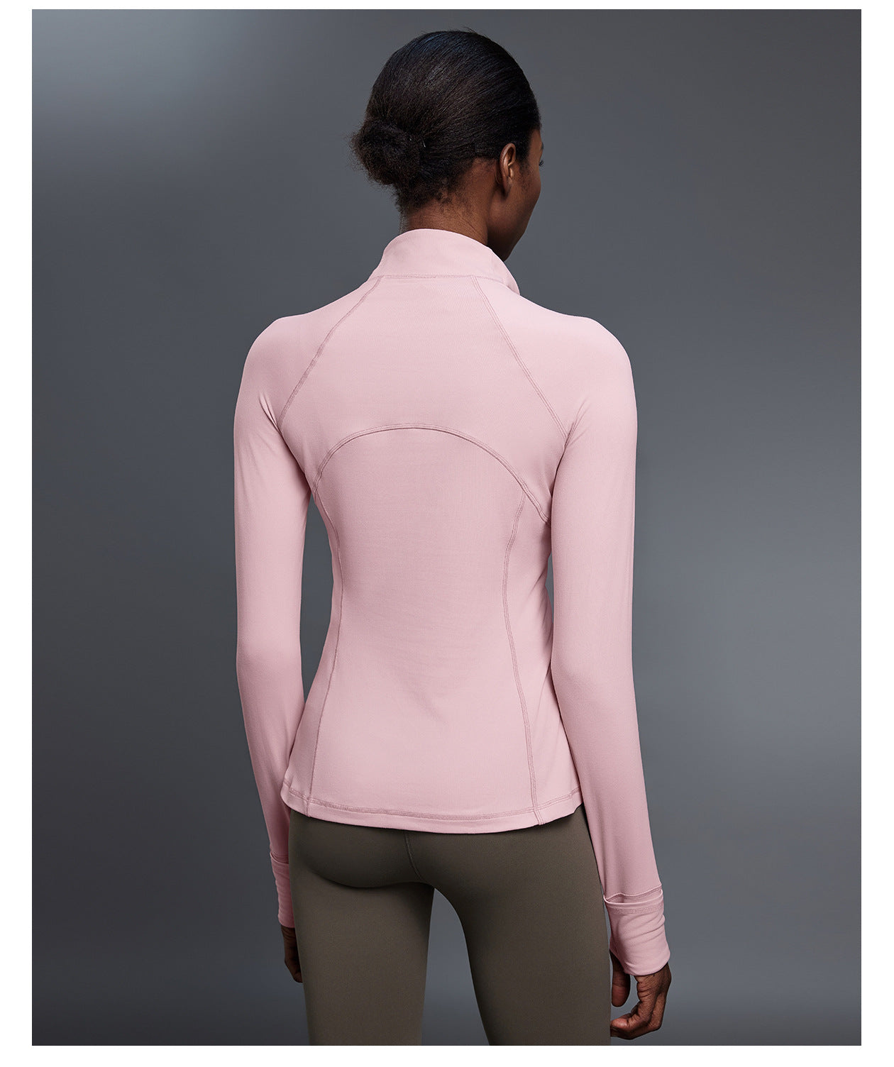 Back view of pink quarter-zip golf pullover showing the stand collar, raglan sleeves and curved back seams