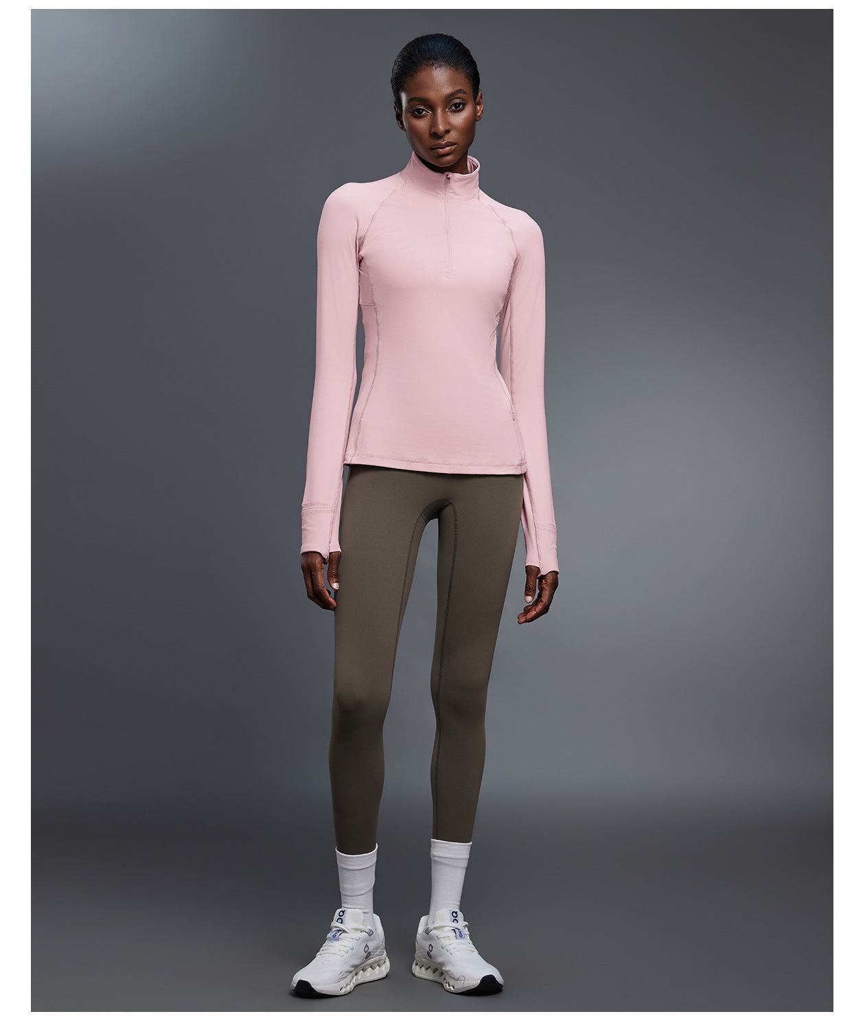 Pink quarter-zip golf pullover with olive leggings, full-length front view showing the fitted shape