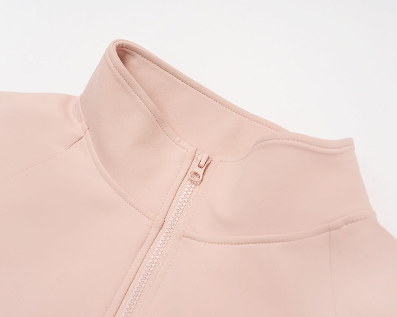 Close-up of the pink jacket stand collar and zipper pull, showing the stitched collar seam
